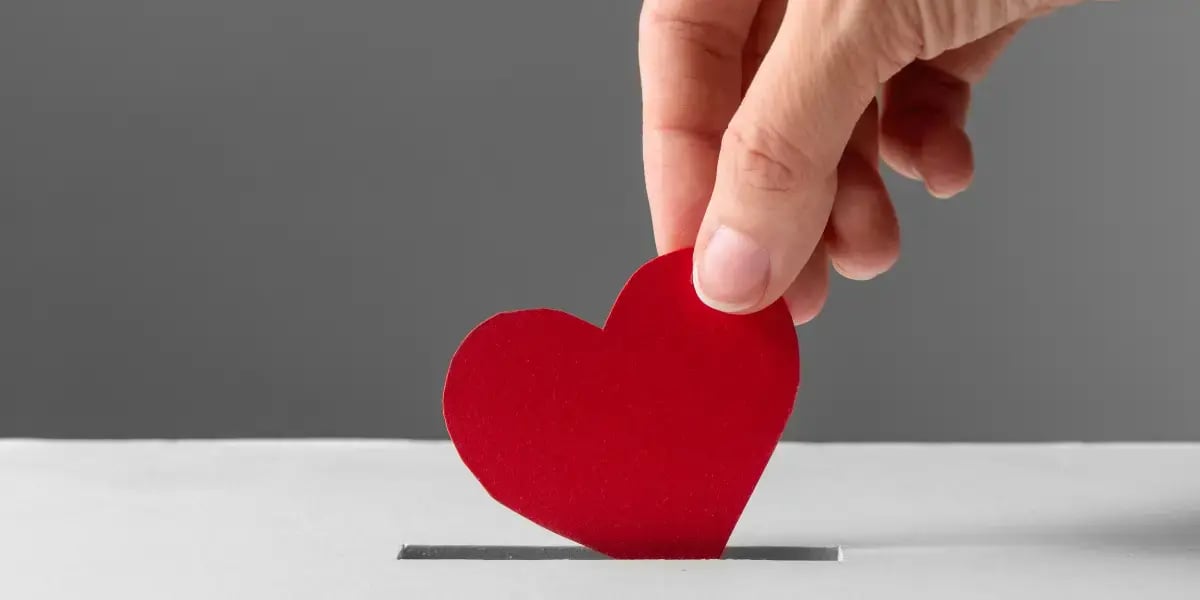 white box with a hand dropping a heart into it