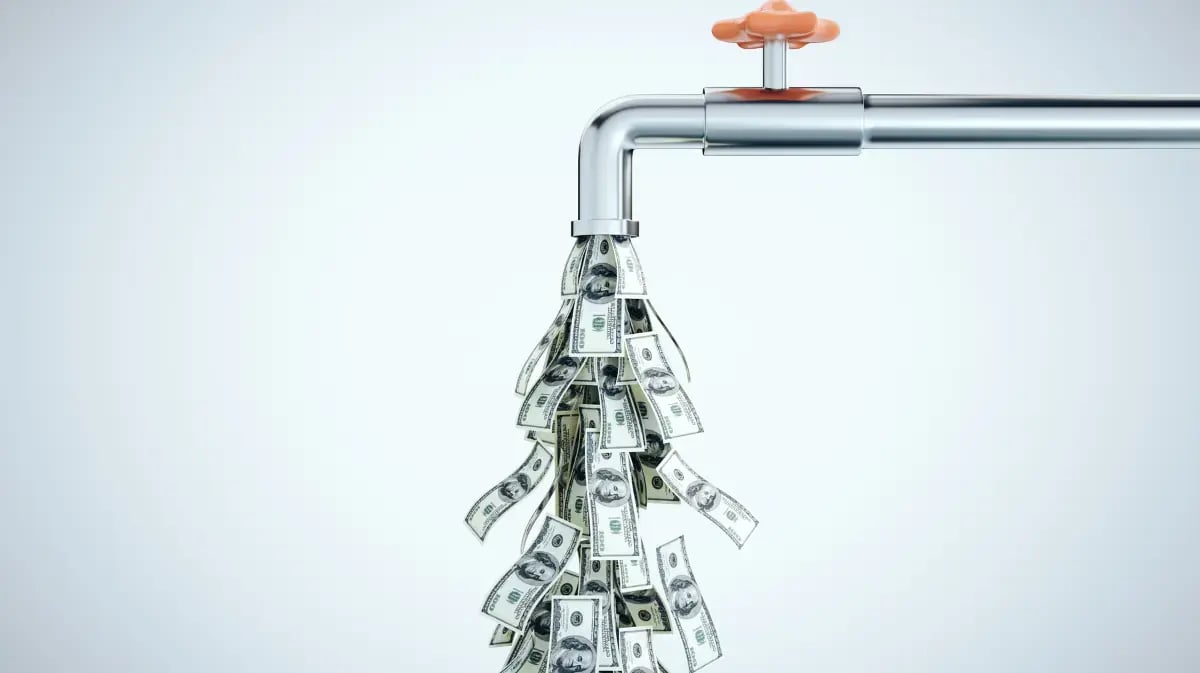 money bills pouring out of a faucet