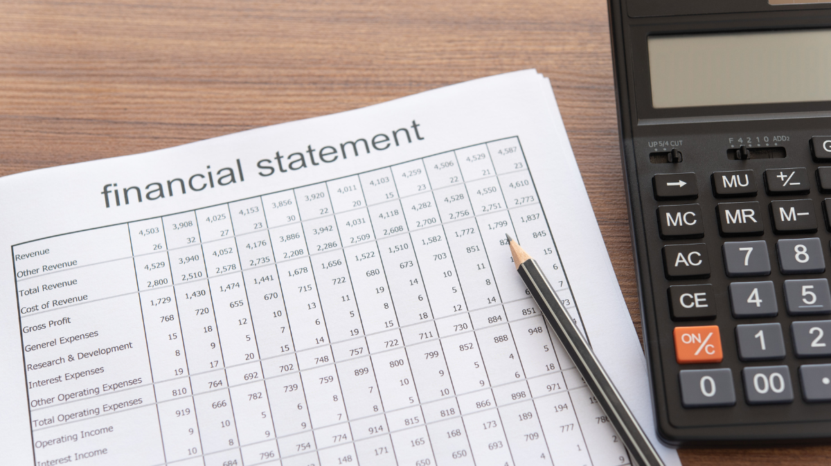financial statement on a desk with a pen and calculator next to it