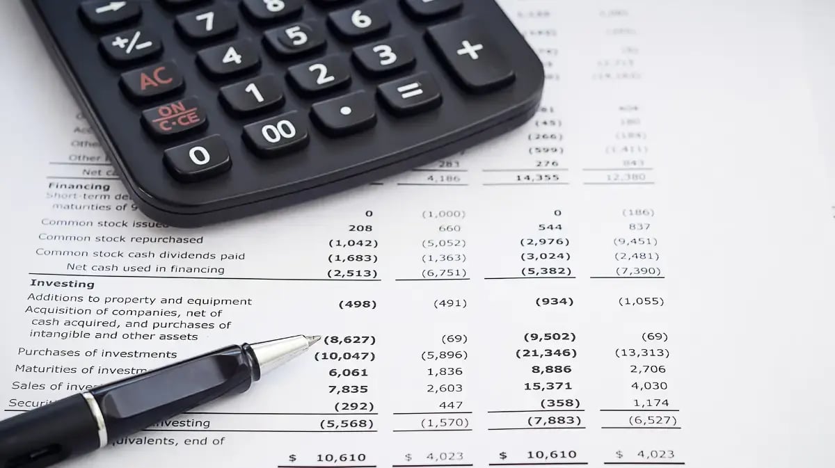 financial numbers on paper with pen and calculator