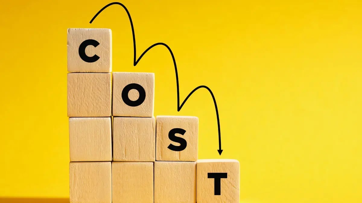 Cost written out on wooden blocks with a yellow background