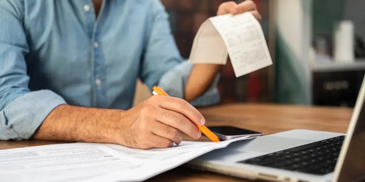 Business owner calculating their expenses at a desk