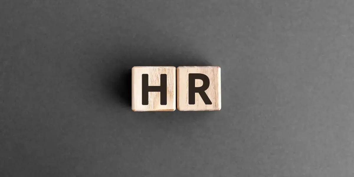 grey background with wooden blocks that spell HR 