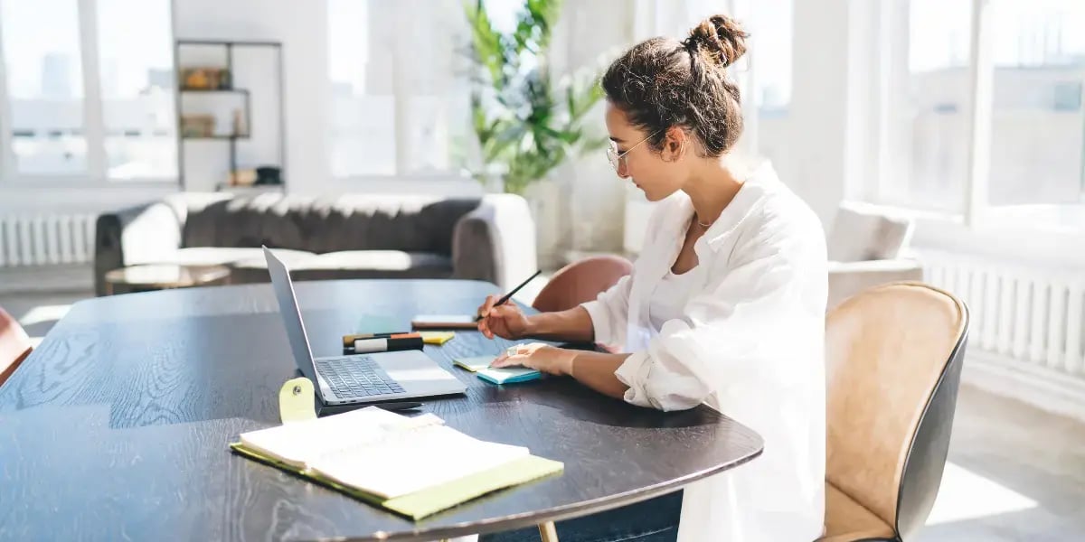 self-employed business owner working on her laptop at a table