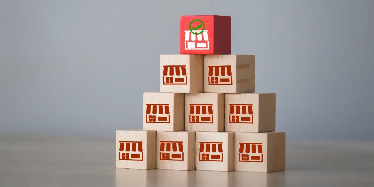 wooden blocks with store icons stamped on them in a stack with a different colored one on top