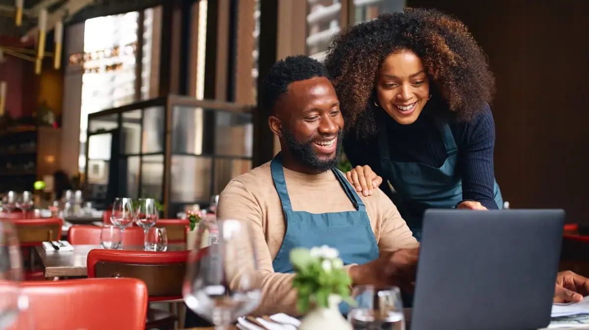 couple sitting at their small business working on a laptop