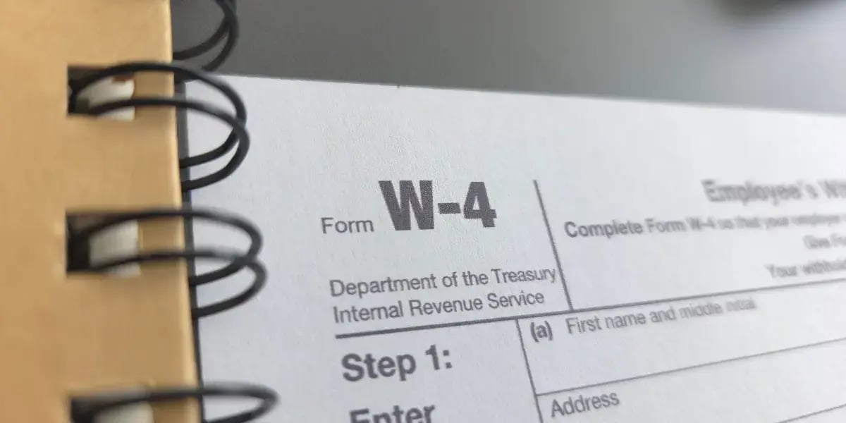 form W-4 sitting next to a spiral notebook