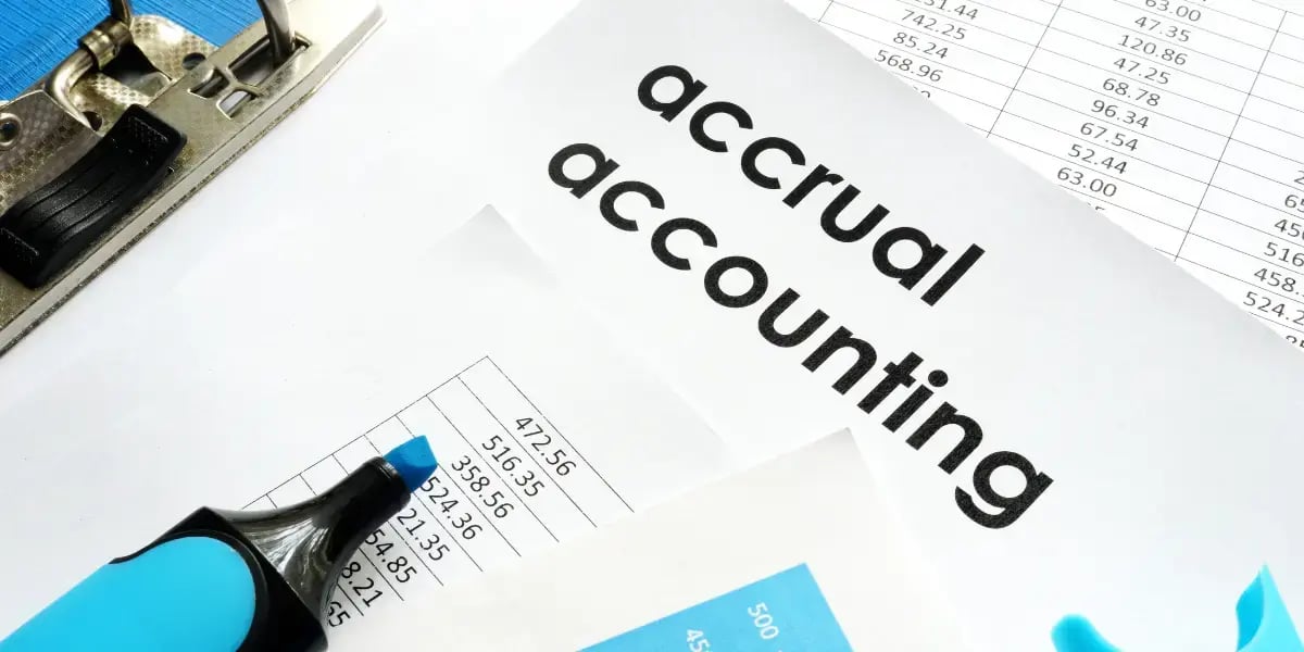 accrual accounting papers on a desktop with a highlighter